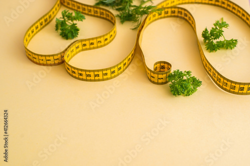 Diet concept on yulow background with measuring tape isolated