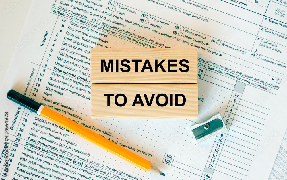 Obraz premium Wooden blocks with text Mistakes To Avoid on financial docs