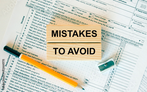 Wooden blocks with text Mistakes To Avoid on financial docs