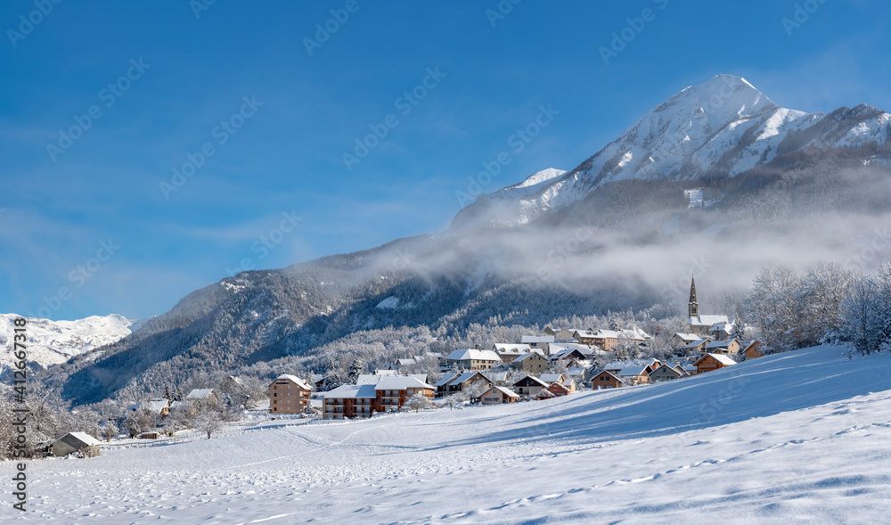 The village of Saint Leger les Melezes in the Champsaur Valley covered in snow in winter. Ski resort in the Ecrins National Park, French Alps, Hautes Alpes, France