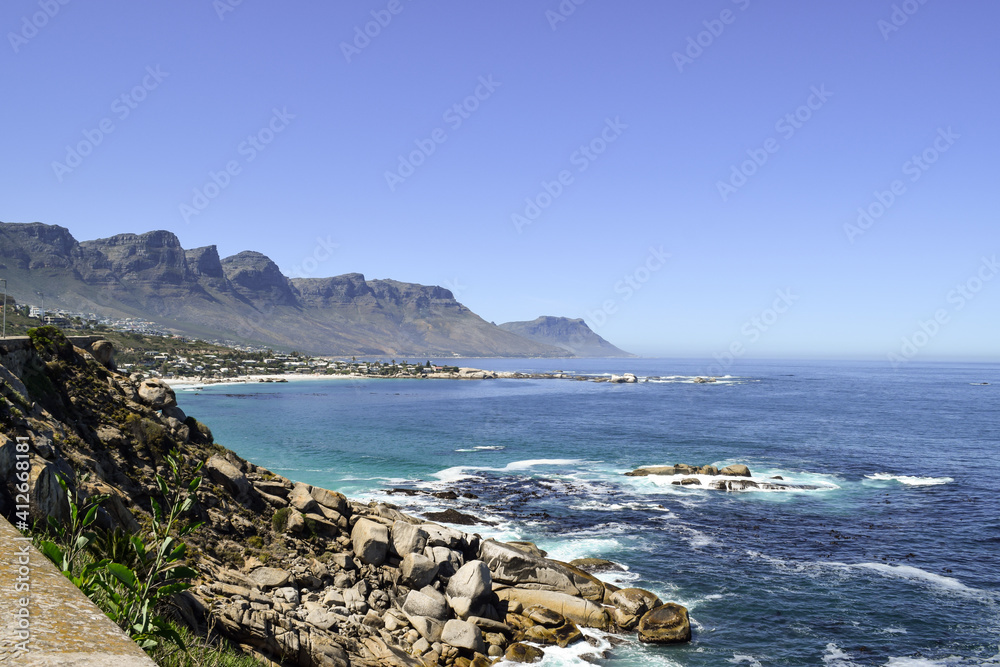 Beautiful view of the beach in Cape Town. Rocks, the sea and Twelve Apostles Mountain Range in the background.