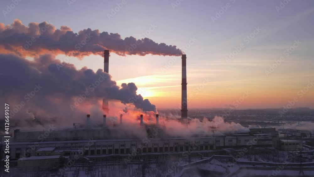 Environmental problem of pollution of environment and air in cities. Smoking industrial zone factory chimneys. View of large plant with industry pipes