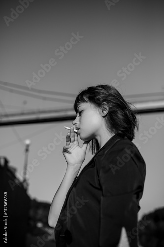 girl in black sexy smokes on the embankment