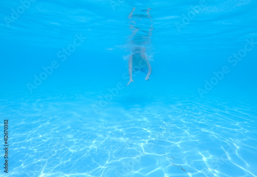 boy swimming in pool with blue water in vacation