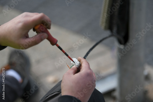 
A city electricians work with wiring affiliated with traffic lights and safety signals. Servicing traffic lights. Close up traffic light pole have problem, cable and wire showing outsite.