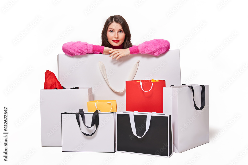 Woman sitting behind shopping bags on white background Woman sitting behind shopping bags on white background