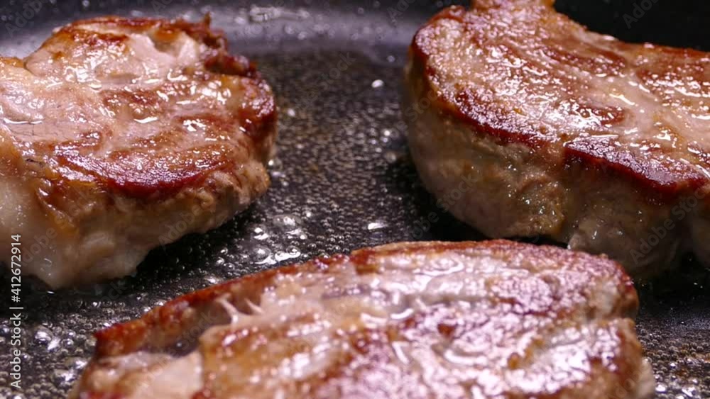 Fry the steak in a pan. Prepare a dish of pieces of meat. Pork with crispy crust close-up.