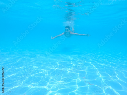 boy swimming in pool with blue water in vacation