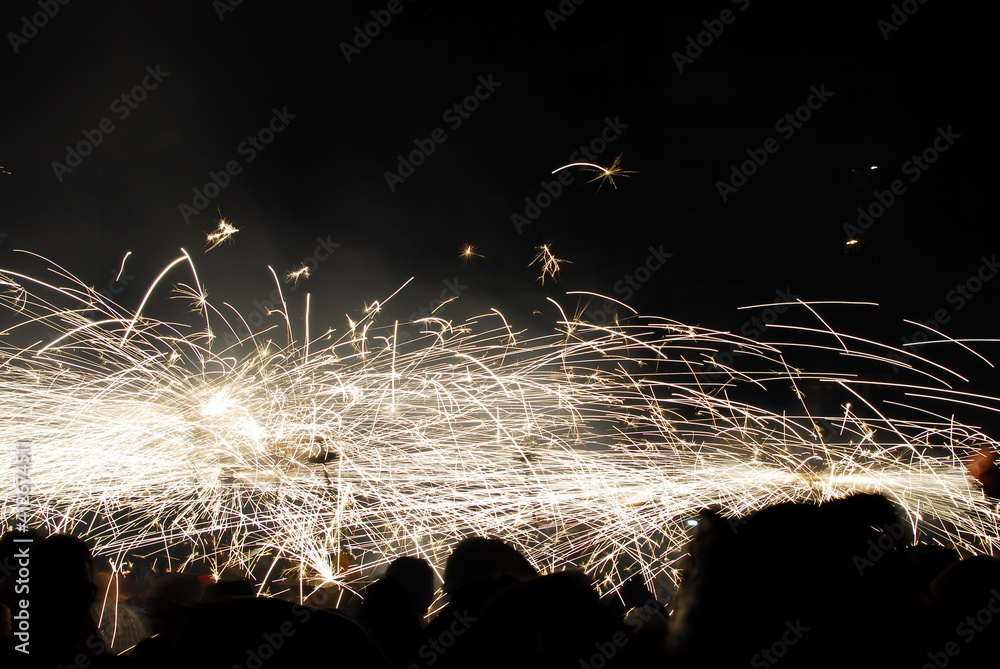 People playing with pyrotechnics in the street at a village. People having fun