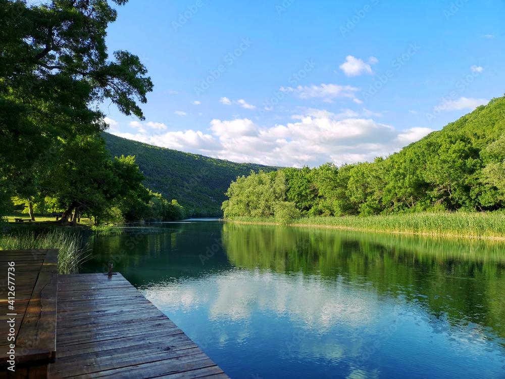 Beautiful calm river surrounded by trees on a sunny day. Beautiful calm river surrounded by trees on a sunny day.