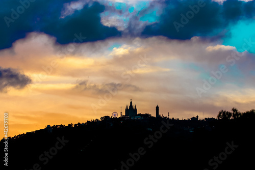 Barcelona  Spain  August 2019. A punxes house. A fairy-tale castle in a contrail on top of a slope against a contrasting evening sky. Contrasting blue clouds against a yellow sky.