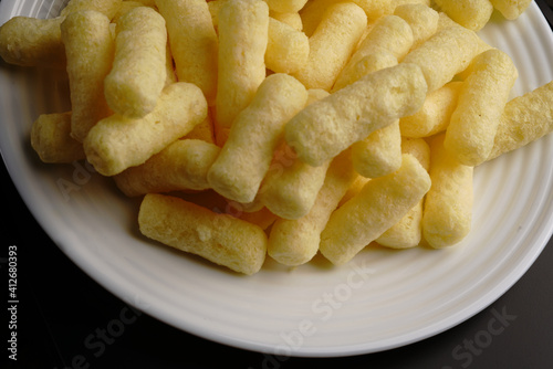 Corn sweet sticks on a white plate top view. Golden color.