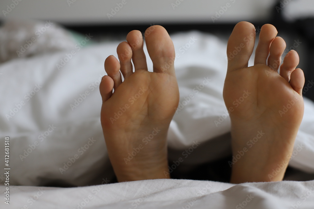 feet in bed. Relax massage, woman’s foot feet in bed. Relax massage, woman’s foot