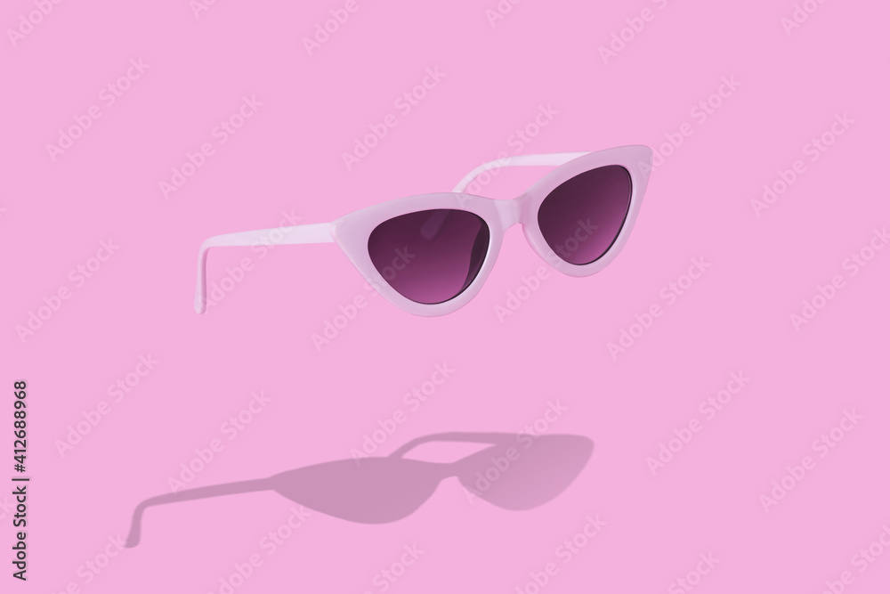 Trendy white sunglasses with shadow on pastel pink background