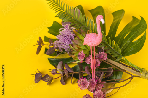 Fototapeta Naklejka Na Ścianę i Meble -  Trendy Summer idea made with pink flamingo figure on bright illuminating yellow background