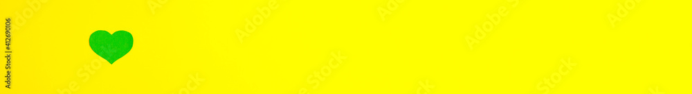 Flat lay top view banner of green heart at the left with copy space on yellow background Saint Patrick's Day 17 march traditional spring celebration holiday and good luck concept Flat lay top view banner of green heart at the left with copy space on yellow background Saint Patrick's Day 17 march traditional spring celebration holiday and good luck concept