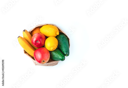 Juicy fresh fruit in a kraft bag isolated on a white background. Top view with copy space. The concept of healthy eating.