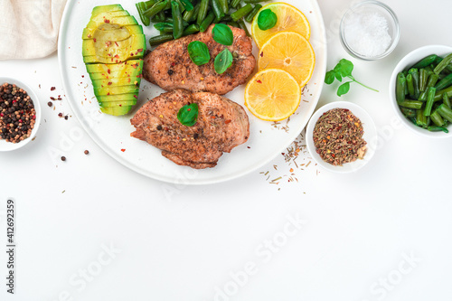 Fresh breakfast with avocado and fried breast with beans on a white background. Top view, with space to copy. The concept of dietary dishes.