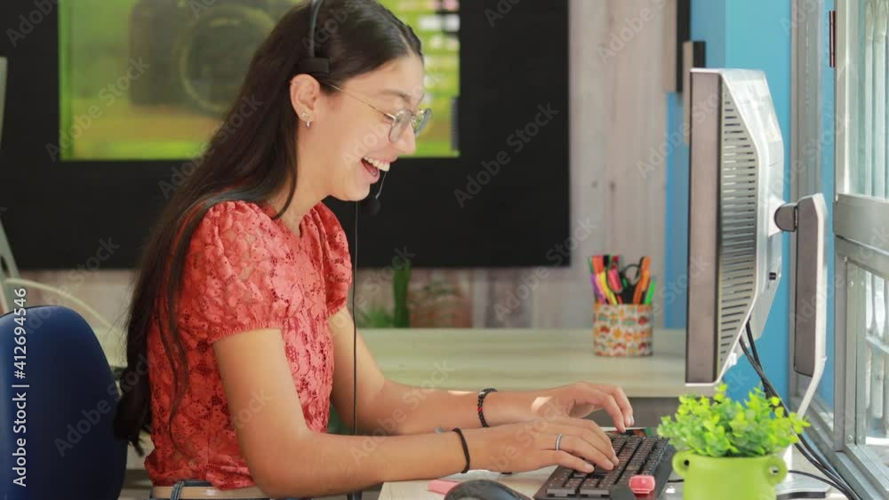 young latina long-haired woman with glasses laughing in a video chat young latina long-haired woman with glasses laughing in a video chat
