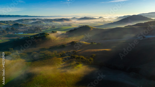 Aerial view countryside farm hills and valleys at sunrise with fog, California © heyengel