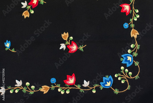 The horizontal photo of the traditional Norwegian vest-coast embroidery ornament, called Frafjord,  on the black woolen fabric photo