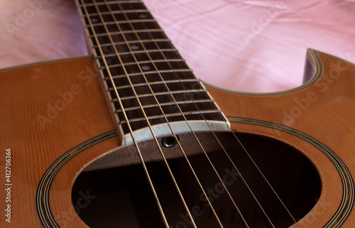 Closeup of the sound hole of an electric-acoustic guitar, with thick strings and an enamel fret board, London, Ontario, Canada. 