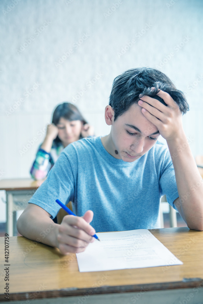 Thinking caucasian boy at school during exam Thinking caucasian boy at school during exam