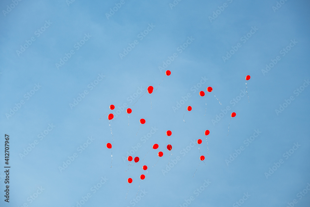 a group of red balloons flying high in the sky
