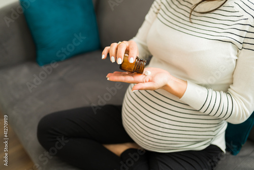 Expectant mother holding a bottle of prescribed pills