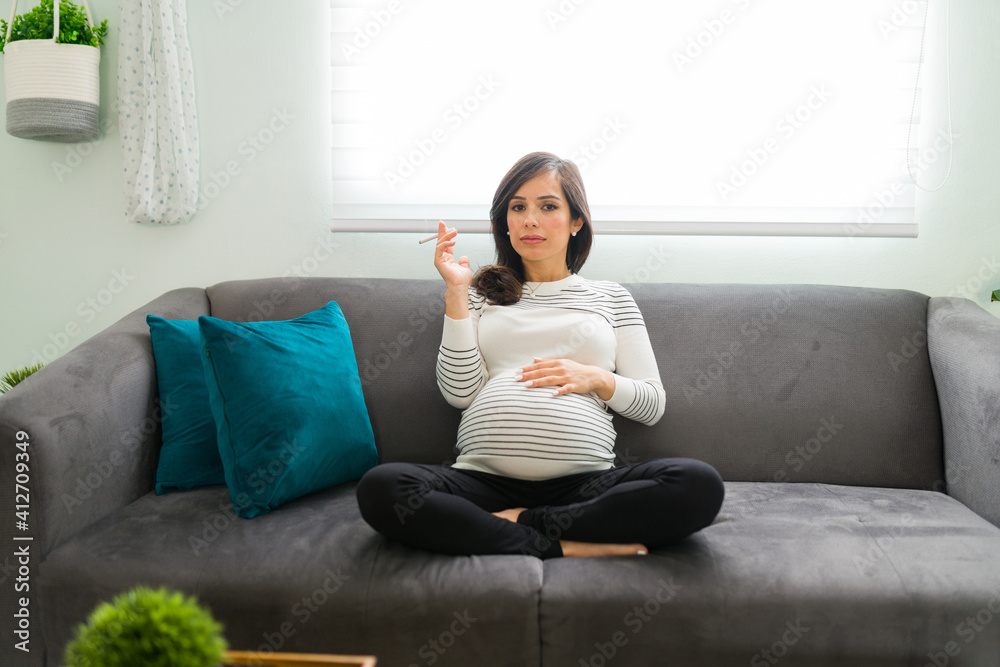 Woman with a risky pregnancy holding a nicotine cigarette Woman with a risky pregnancy holding a nicotine cigarette