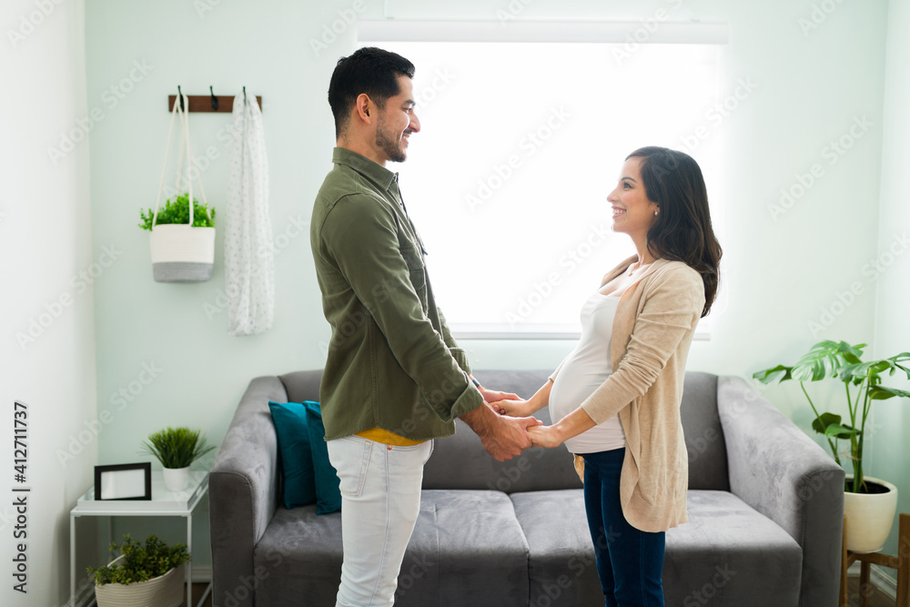 Obraz premium Side view of a pregnant woman and man in love at home