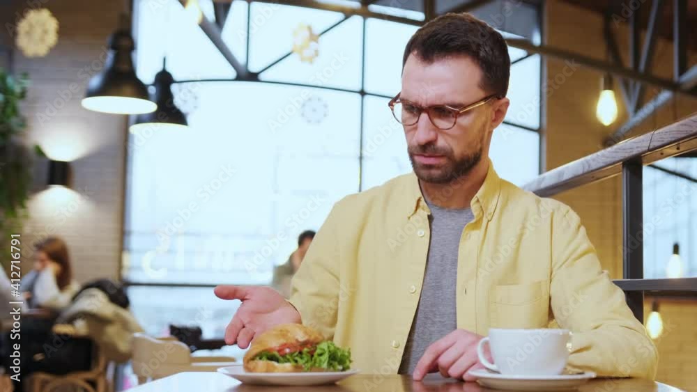 Dissatisfied male expressing displeasure with food talking to excusing waitress in restaurant. the client is dissatisfied with the cafe service