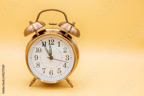 Fototapeta Naklejka Na Ścianę i Meble -  old clock symbolilizes time shortness for things like vaccination and dates ,bottleneck and hurry with yellow background