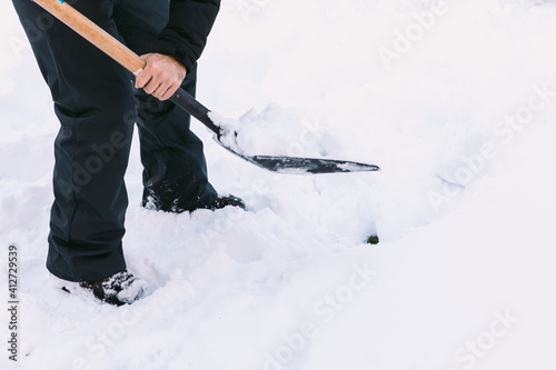Man removing snow from the garden of his house with a shovel © Davidbenito
