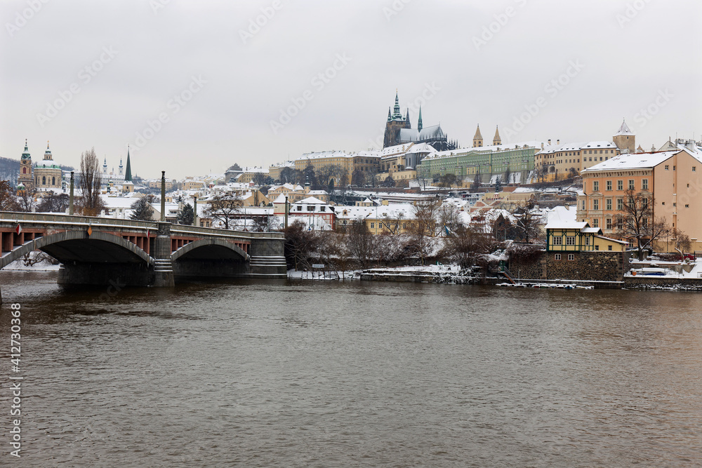Fototapeta premium Snowy Prague Lesser Town with Prague Castle above River Vltava, Czech republic