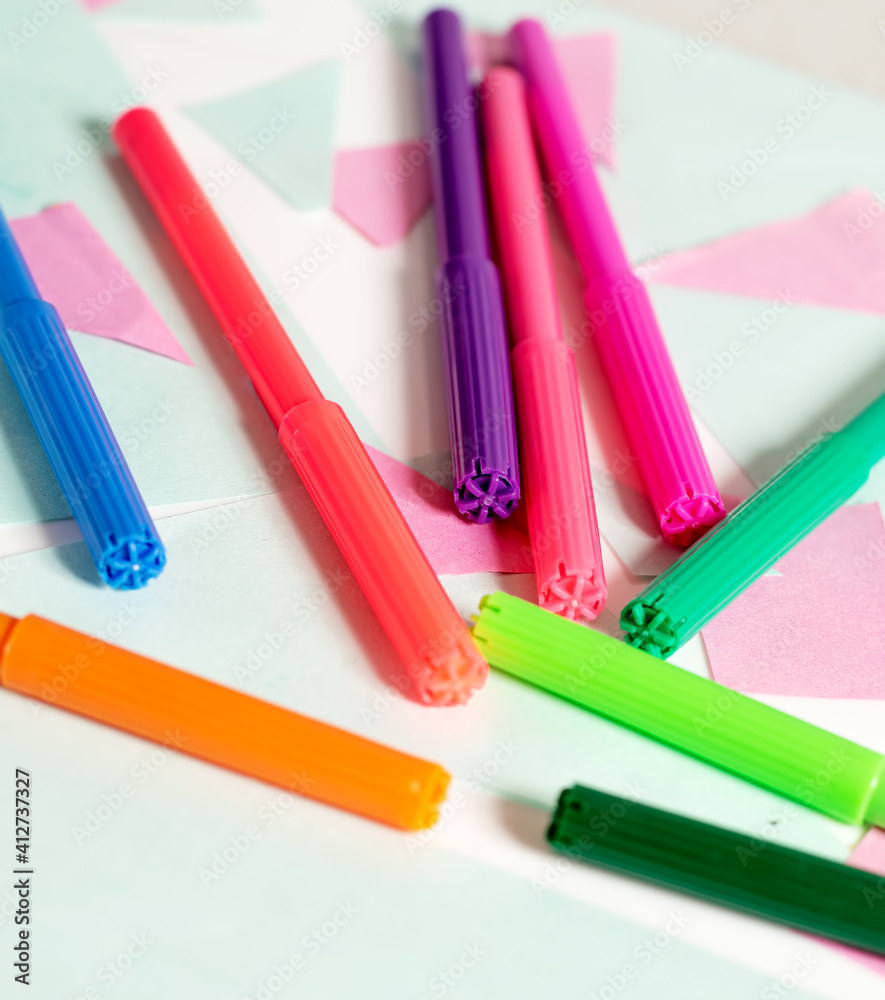 Colorful felt tip pens on a geometric background