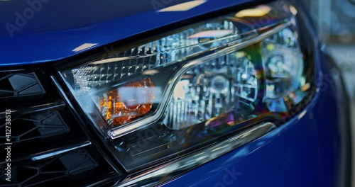 Close-up, headlight of a new blue car in a dealership, modern design. Headlight, Xenon. Bixenon. 4k, ProRes photo