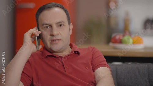 Young man talking by cell phone.A business man working from home is organizing his work by phone.