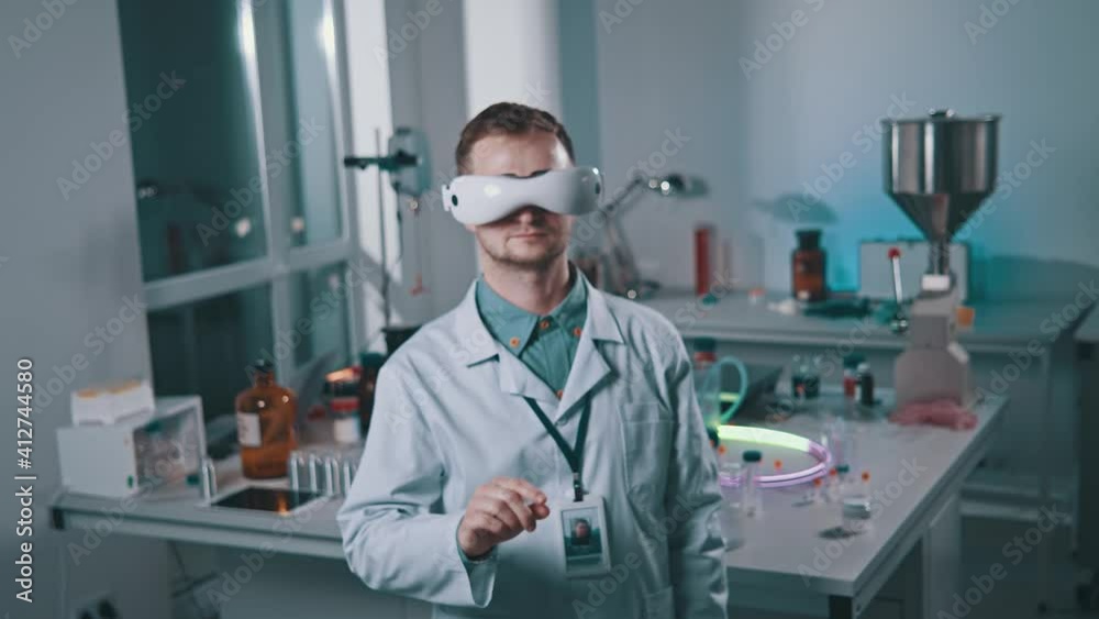 In laboratory room young scientist man using vr glasses virtual reality innovative scientist. Medic, tech, modern, analyzing, innovation, future. Slow motion In laboratory room young scientist man using vr glasses virtual reality innovative scientist. Medic, tech, modern, analyzing, innovation, future. Slow motion