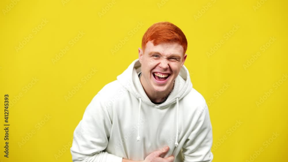 Portrait of joyful redhead Caucasian man laughing out loud looking at camera. Cheerful relaxed millennial posing at yellow background. Fun and leisure concept. Portrait of joyful redhead Caucasian man laughing out loud looking at camera. Cheerful relaxed millennial posing at yellow background. Fun and leisure concept.