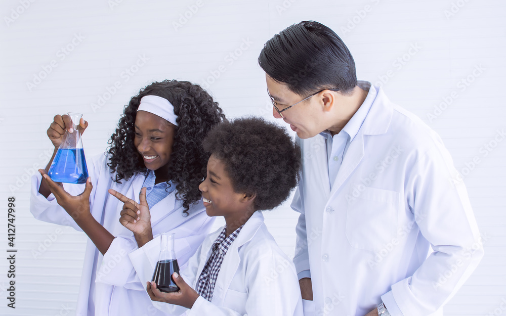 Teacher teaching science to african black boy and girl at school Teacher teaching science to african black boy and girl at school