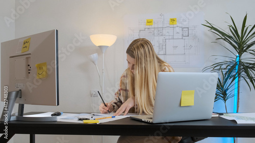 The girl is a freelancer writes in a notebook ideas. Work from home.