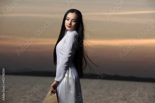 Portrait of Beautiful Asian girls with Ao Dai vietnam traditional dress on Sunset landscapes..