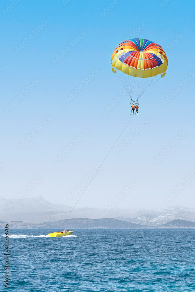 Colorful parasail wing pulled by a boat. Water fun activities. Colorful parasail wing pulled by a boat. Water fun activities.
