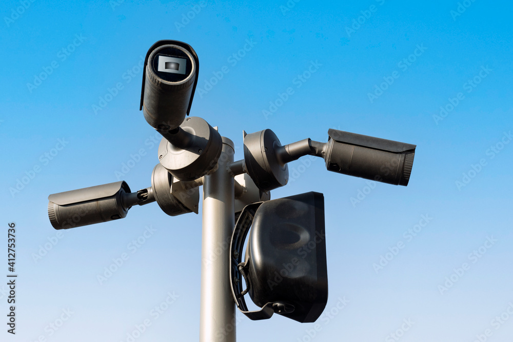 Camcorders on the pole on blue sky background. Security system.