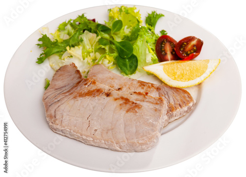 Close up of mediterranean tuna steak on plate. Isolated over white background