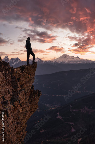 Adventurous man is standing on top of the mountain and enjoying the beautiful view. Taken on top of Cheam Peak in Chilliwack, East of Vancouver, BC, Canada. Colorful Sunset Sky Art Render © edb3_16