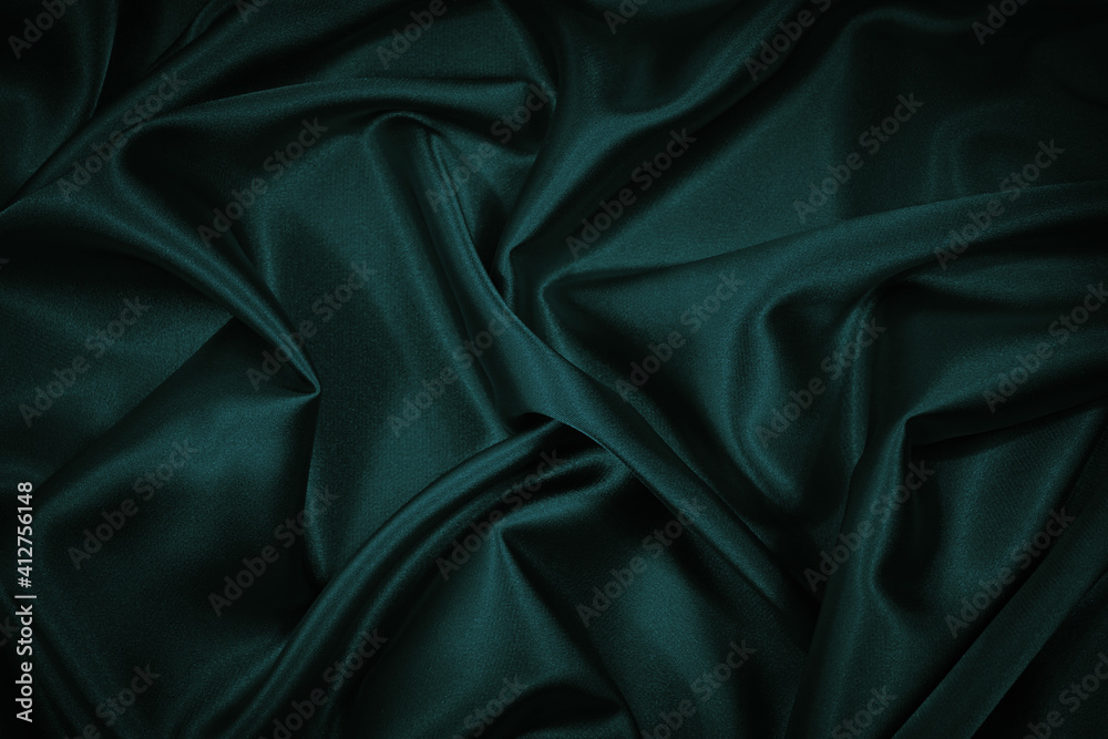 Fototapeta premium Black blue green abstract background. Dark green silk satin texture background. Beautiful wavy soft folds on the surface of the fabric. Teal elegant background with copy space for design. Web banner.