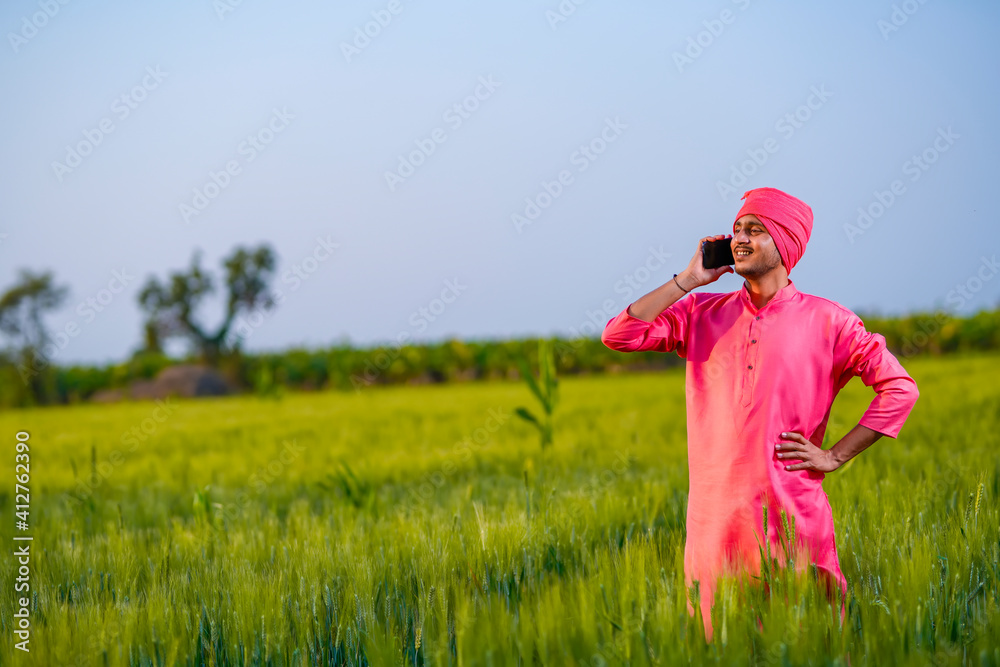 Young indian farmer talking on smartphone at wheat field Young indian farmer talking on smartphone at wheat field