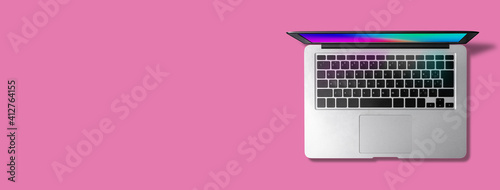 ピンク色の背景に、レインボーカラーの壁紙（オリジナル）を表示したノートパソコン。